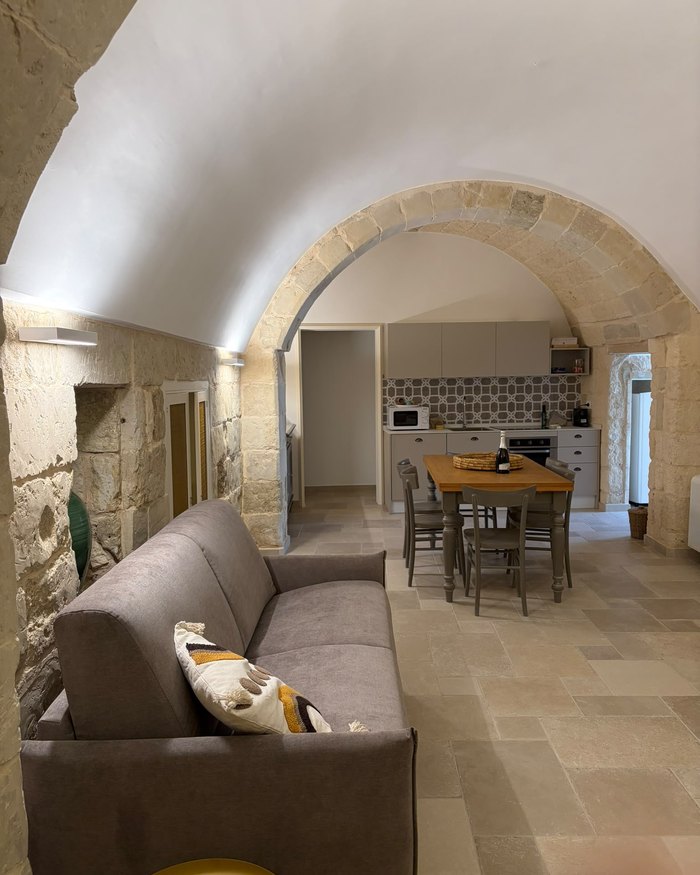 Il soggiorno e la cucina di Zia Nena visti sotto il grande arco in pietra